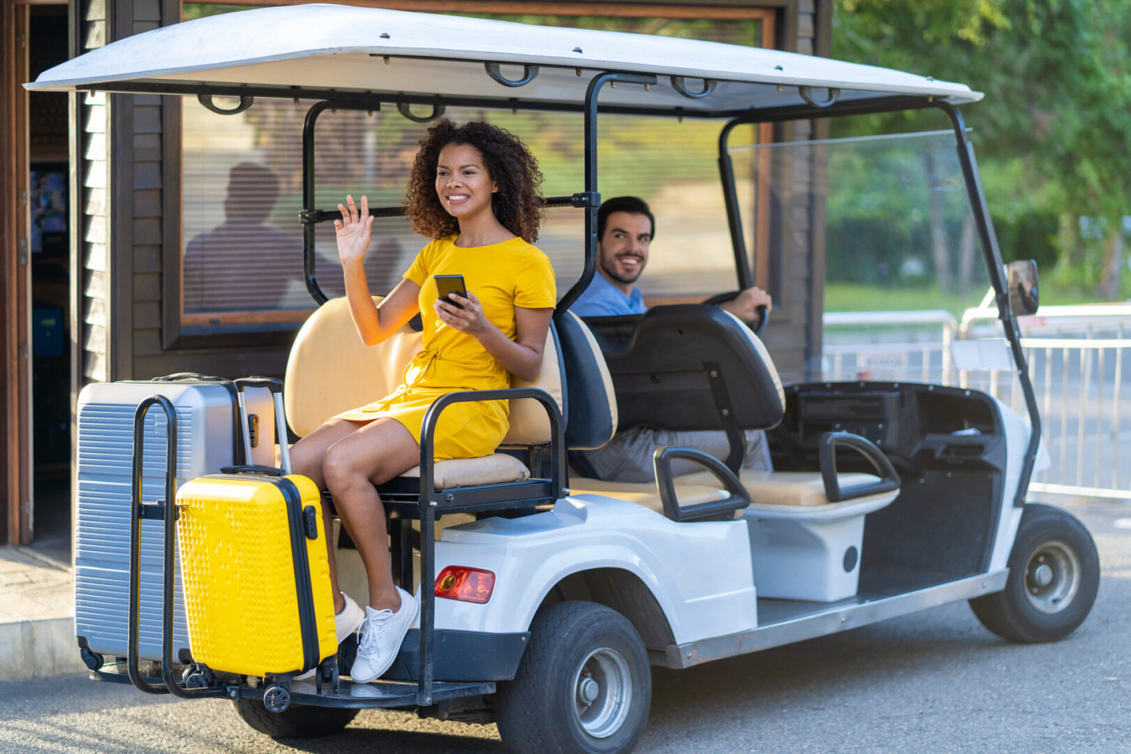 Woman waving on a golf cart ride.